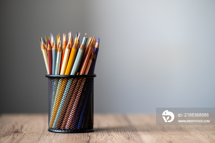 colored pencil in a black jar on a wooden table Online learning concepts at home