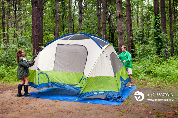 Man and woman preparing camping tent