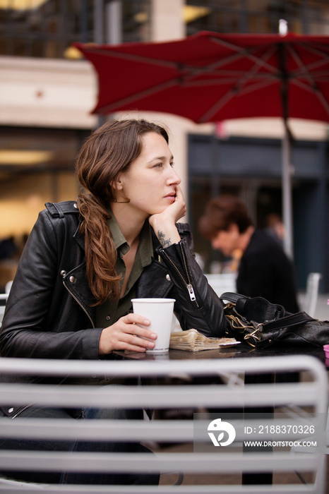 Young woman sitting at table in outdoor cafe