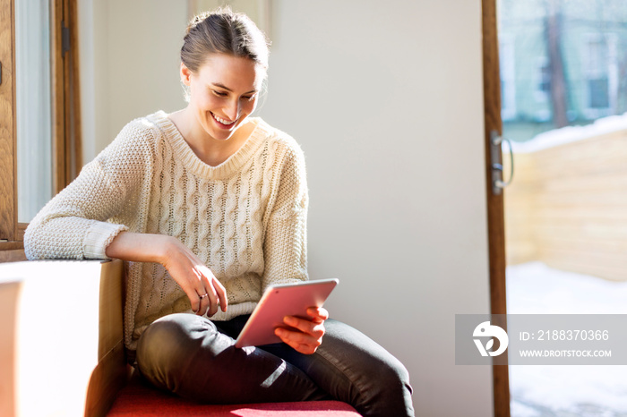 Smiling woman using digital tablet