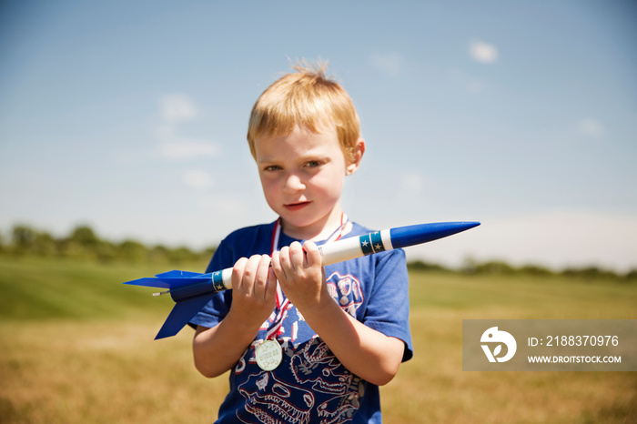 Portrait of boy (2-3) holding model rocket