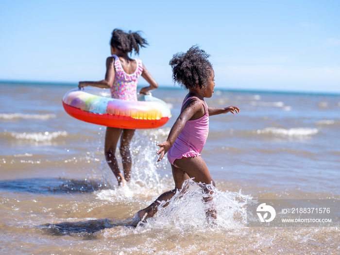 Sisters (2-3, 6-7) playing in sea