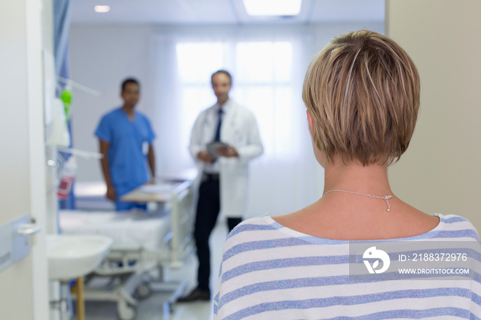 Woman approaching doctors in hospital room