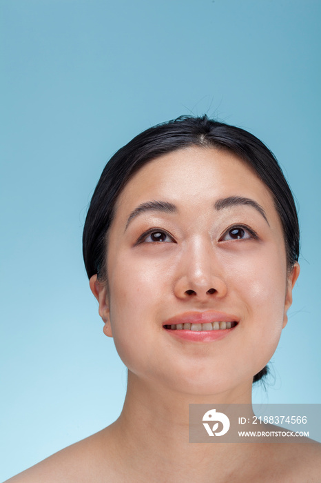 Studio portrait of woman against blue background