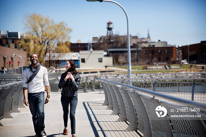 Smiling couple walking along bridge