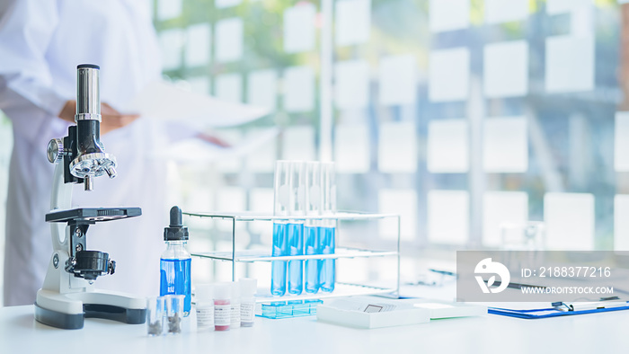 医学或科学研究人员或男医生在实验室里看着透明溶液的试管