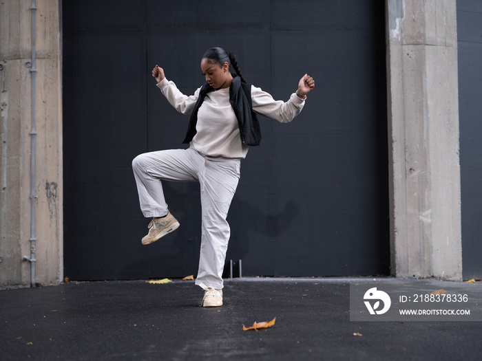 Teenage girl in sports clothing dancing in city