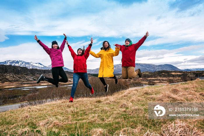 four friends jump on dry grass in Iceland