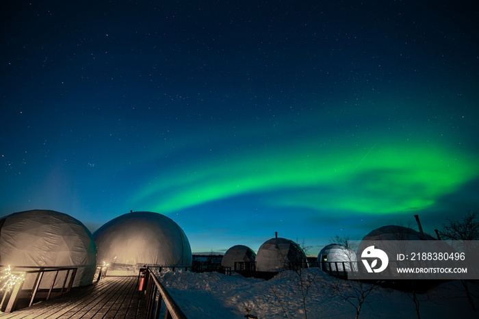 Northern Lights also known as aurora, borealis or polar lights at cold night over igloo village. Bea