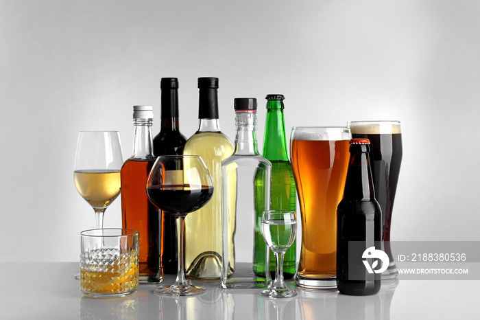 Glasses of wine and spirits on light background