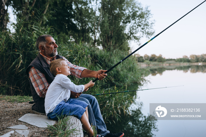 男孩和爷爷在湖边钓鱼