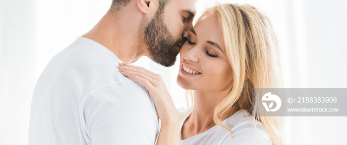 panoramic shot of beautiful romantic couple embracing at home