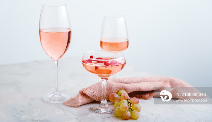 不同类型玻璃杯中的玫瑰酒，浅混凝土背景，葡萄。葡萄酒成分o