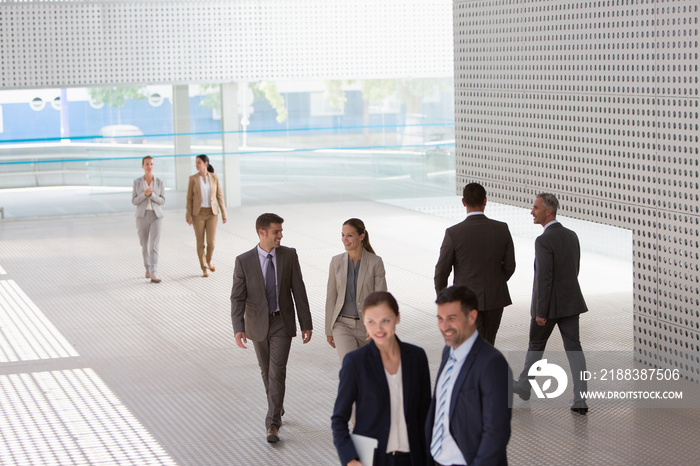 Corporate business people walking in modern lobby