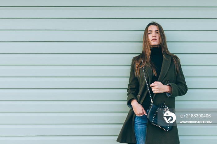 Attractive girl with long hair in a green coat