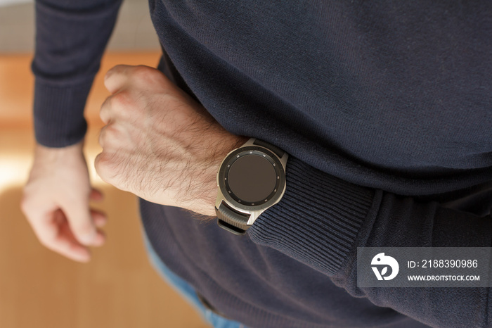 Business Man uses a smart watch on his hand inside of the office. Close up look.