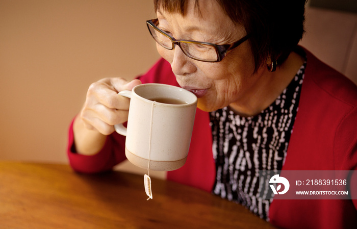 女性坐在桌子旁喝茶的高角度视角