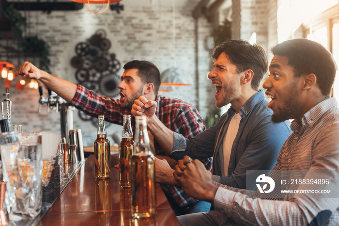 Diverse friends watching football game in bar