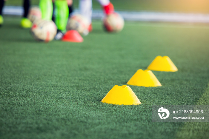对红色锥形标记的选择性关注是在模糊的绿色人造草坪上的足球训练设备