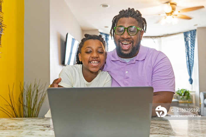 Father and daughter Êusing laptop at home