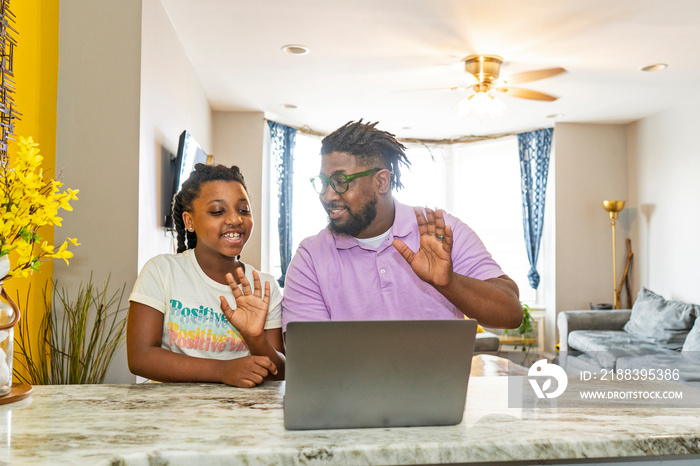 Father and daughter Êusing laptop at home