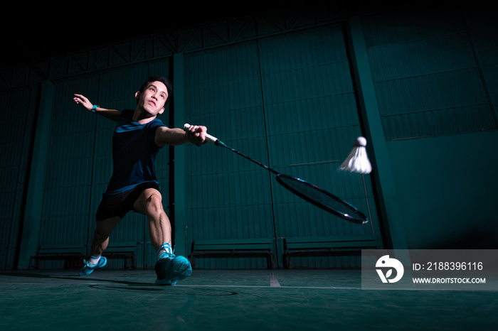 职业羽毛球运动员在热身赛中使用球拍击打球场上的梭子或羽毛球