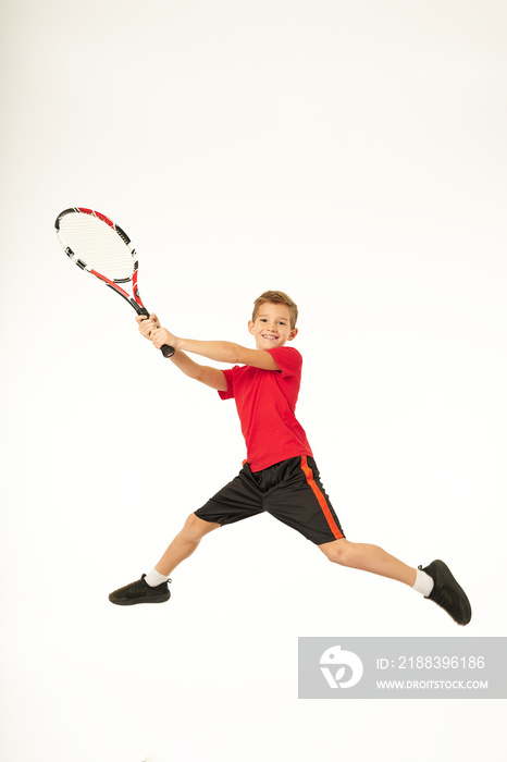 快乐的男孩跳跃和打网球