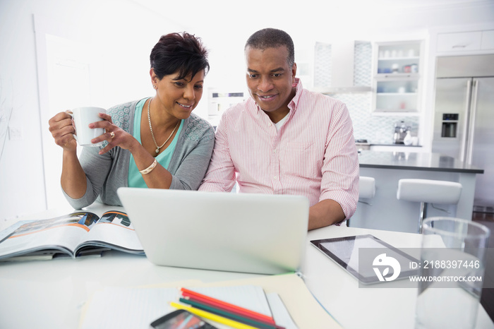 Mature couple using laptop together at home