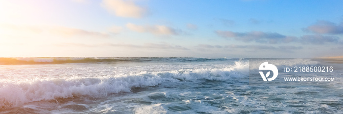 Beautiful View on high waves on the empty coast of the Atlantic Ocean, blue sky with clouds and sunbeam. Deserted beautiful ocean beach. Long sea banner.