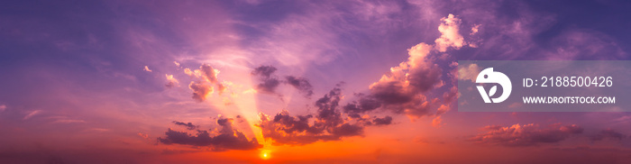 Panorama Sunlight with dramatic sky. Cumulus sunset clouds with sun setting down on dark background.Vivid orange cloud sky.