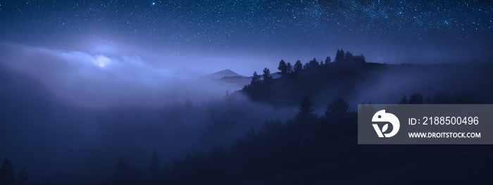 Beautiful moonrise over the foggy mountains at night