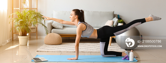 Sporty young woman doing pilates at home