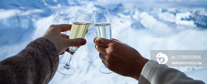 couple drinking champagne and snowy mountains winter holiday