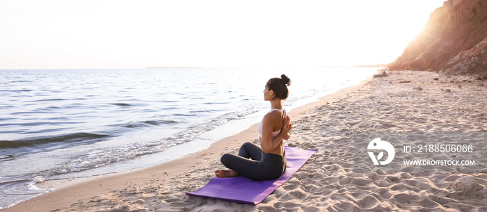 Woman practicing yoga on sea shore