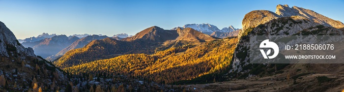 Sunny colorful autumn alpine Dolomites rocky mountain scene, Sudtirol, Italy. Peaceful view from Falzarego Pass. Snowy Marmolada massif and Glacier in far. High resolution ultra wide panorama.