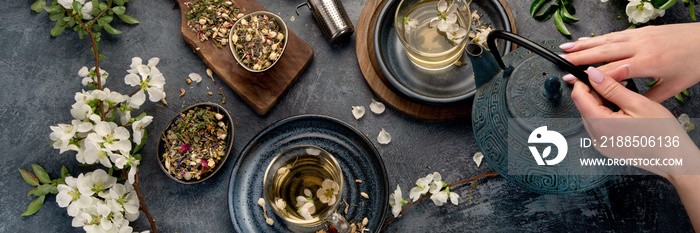 Green herbal tea with cups and teapot on gray backround.