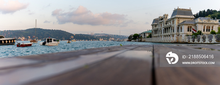 View of the bosphorus, boats, courtyard bench and historical mansions from the beach. Bebe beach. Besiktas Istanbul Turkey