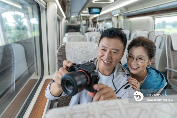 快乐的老年夫妇坐地铁用相机拍照