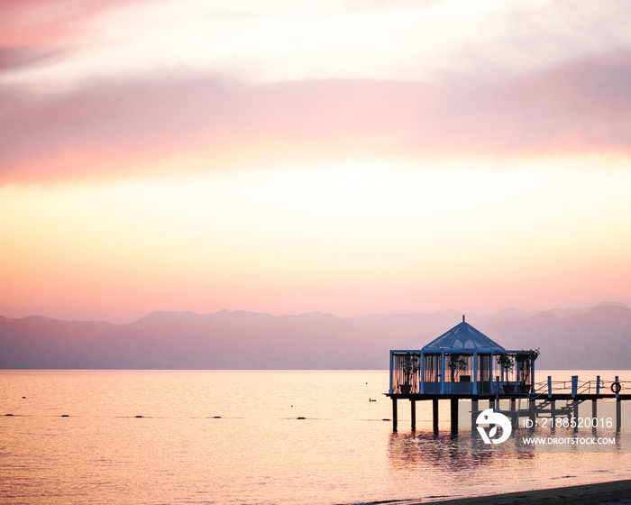 Sunset on the beach, ocean in pink colors. Mountains are visible on the horizon. Turkey, Belek.