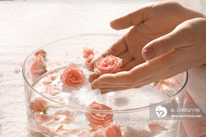 Young woman undergoing spa manicure treatment in beauty salon, closeup