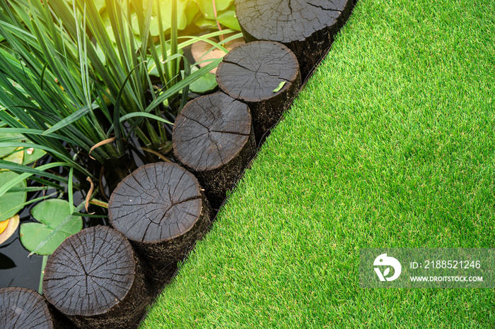 Perfect soft artificial turf behind the decorative pond with water lilies