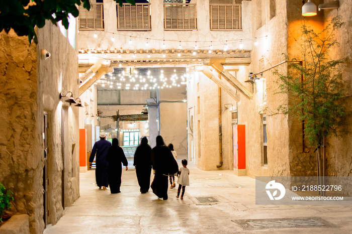 Arab People Walking on traditional stone road in between buildings built in traditional theme