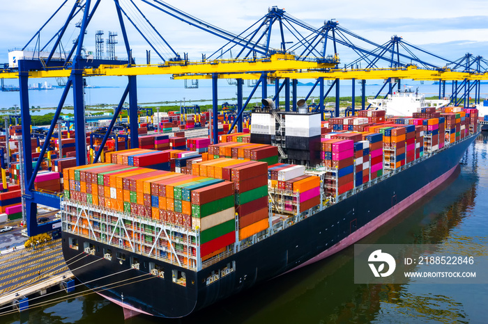 Aerial top view over international cargo ship at industrial import-export port prepare to load containers with big container loader ship vessel. global transportation and logistic business.