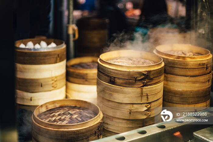 Piles of stacking bamboo steamers are steaming for dim sum. Street food of Jiantan in Taipei, Taiwan. Focus on front bamboo steamers.