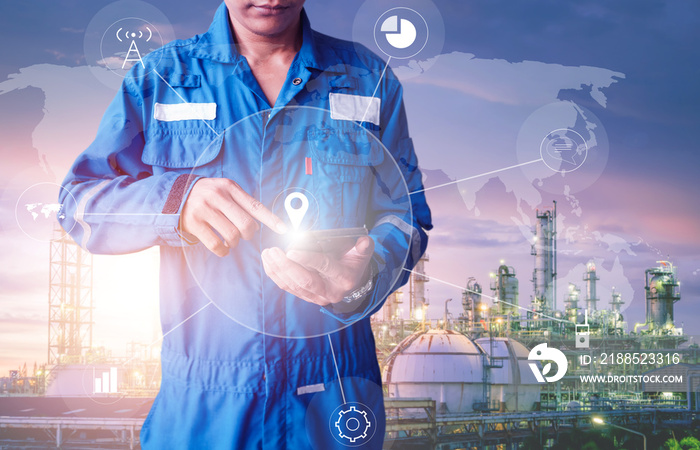 Asia engineer stand holding hand touch of smart phone on oil and gas refinery plant background, Engineer planning work concept, Professional technician monitoring of petrochemical industry plant