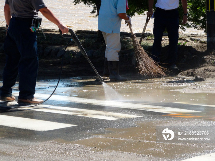 京都嵐山桂川の洪水で道路の泥を取り除く