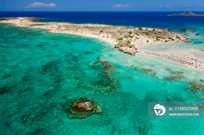 Aerial view of a beautiful but busy sandy beach and shallow lagoons surrounded by clear, blue ocean (Elafonissi, Crete)