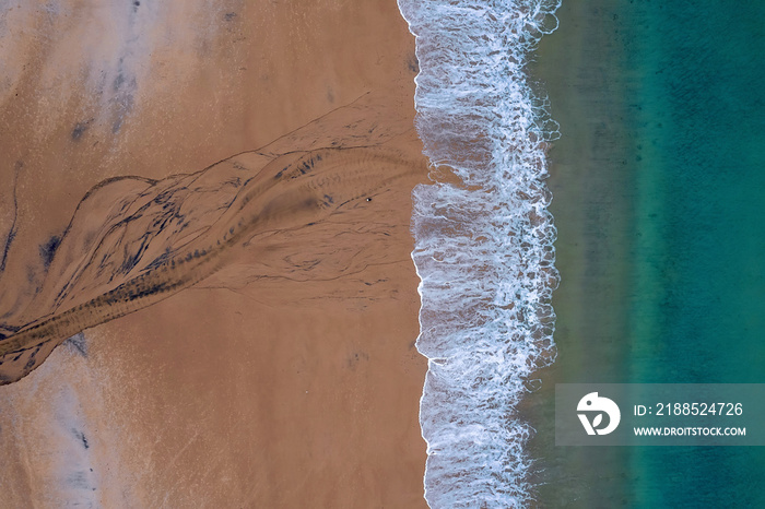 Aerial top down view on a beautiful beach and ocean surface with blue water. Keem bay, Ireland. Nature scene.