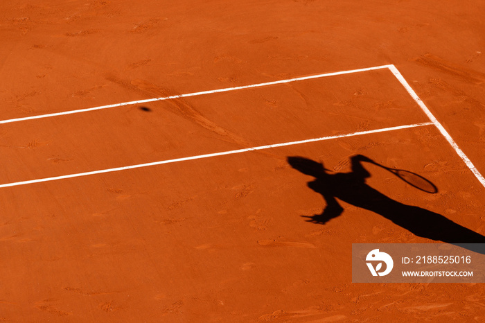 A tennis Clay court and the shadow of a player