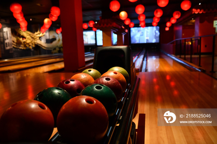 Bowling lane and balls in the row in bowling center.